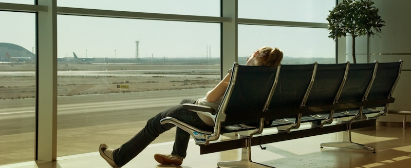 woman sleeps jet lagged in airport