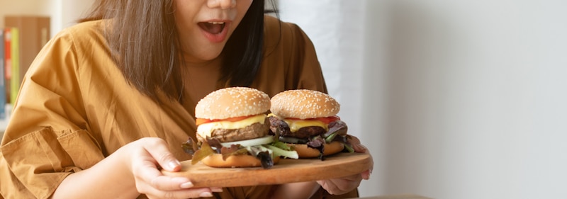 binge eating girl eats two burgers
