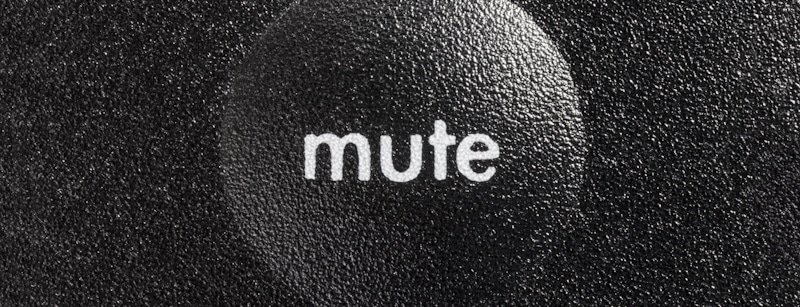 mute spelled on grainy black surface