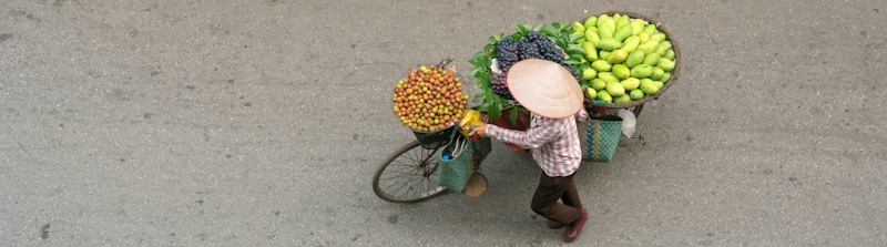 peddler rides his bike as he sales fruit
