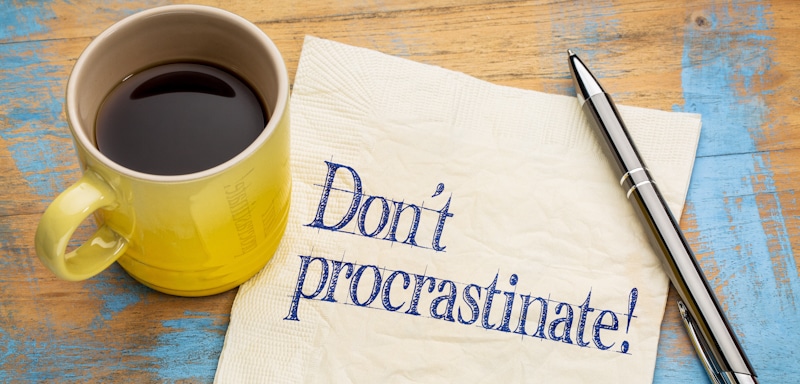 dont procrastinate sign in paper with coffee and pen