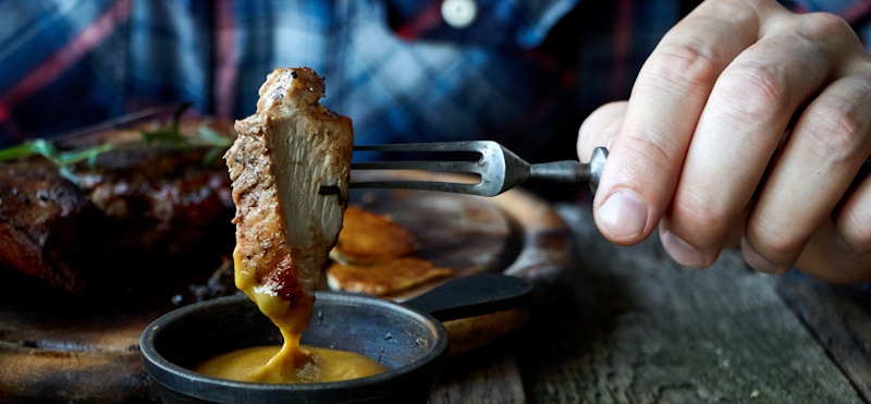 mustard being applied to meat