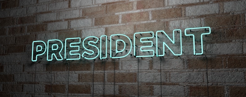 president sign in neon lights brick wall