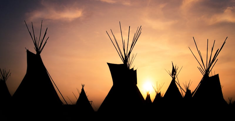 tipis in the shadow of a sunset
