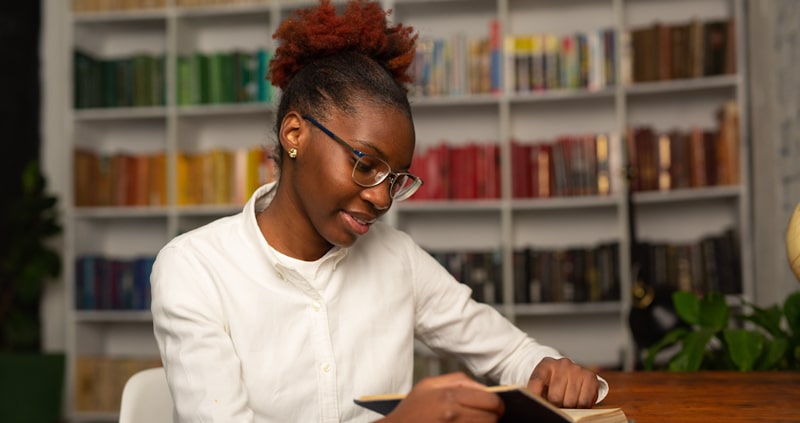 african woman reading library